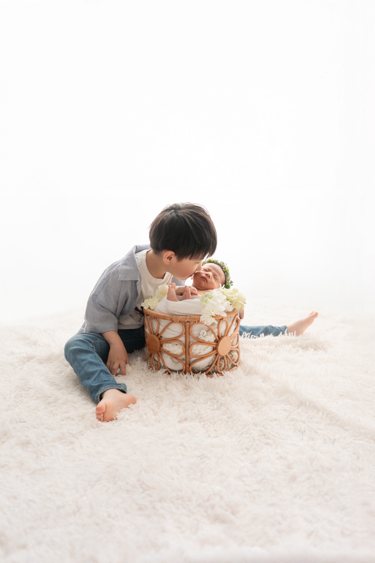 かごのそばに座る男の子の記念撮影